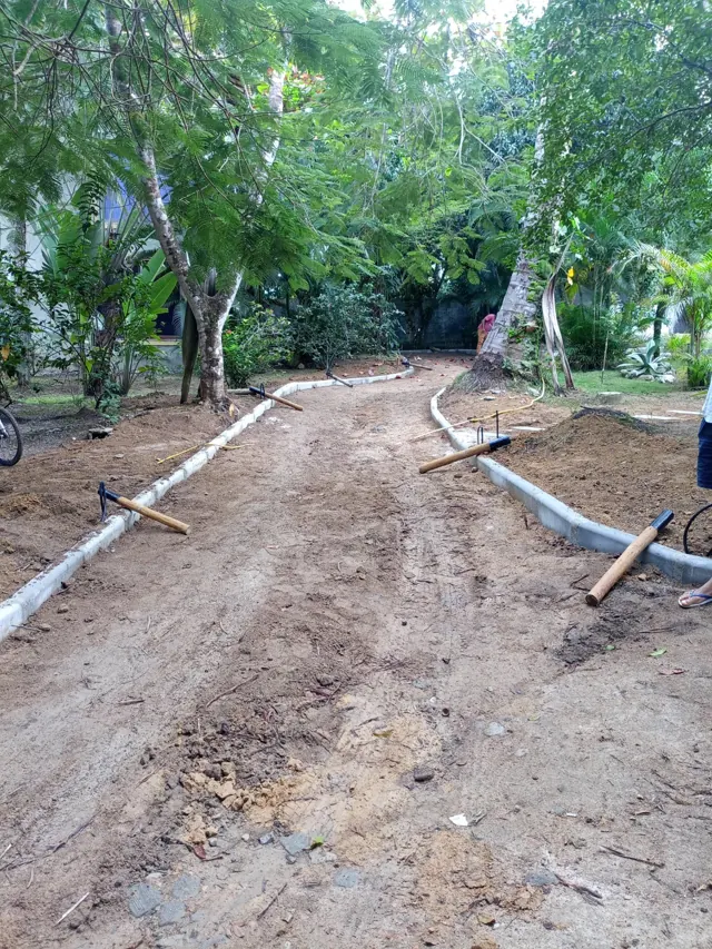 Meio-fio sendo assentado em via interna de condomínio arborizado