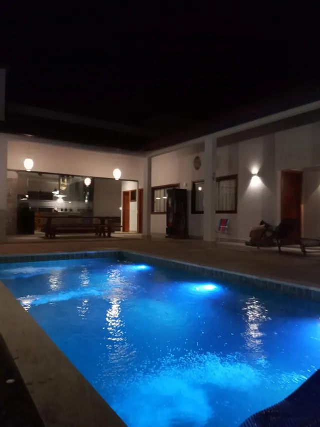 Piscina iluminada à noite em residência entregue