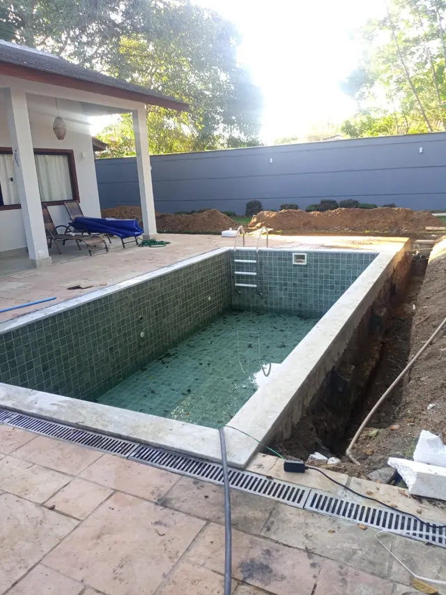 Piscina revestida em execução, com área externa e drenagem no entorno